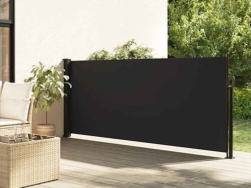 مظلة جانبية سوداء قابلة للسحب مُثبتة على فناء مصمم بجانب مقاعد خارجية ونبتة مزروعة في وعاء. انقر لرؤية المنتجات في المجموعة.